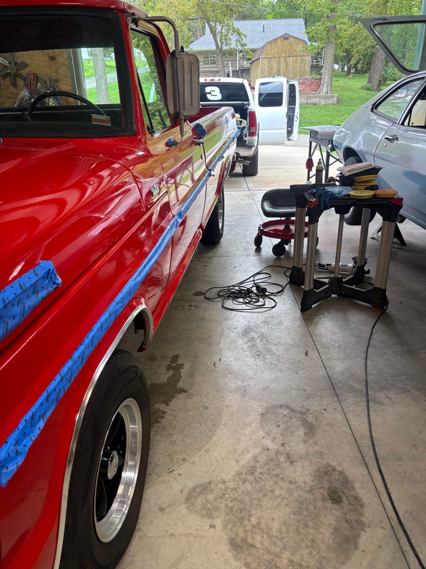 Red classic Ford pickup taped off during professional paint correction and ceramic coating