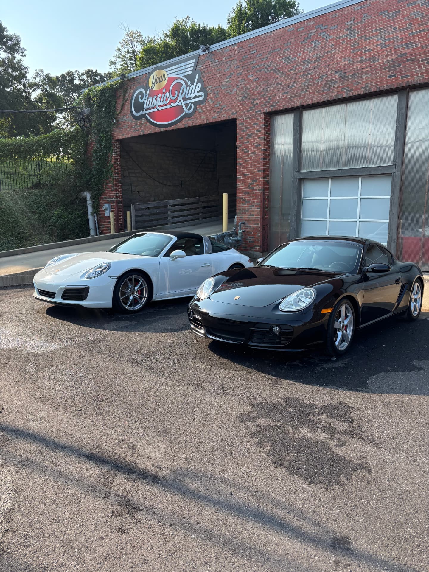 Freshly detailed white Porsche 911 and black Porsche Cayman with a deep glossy finish